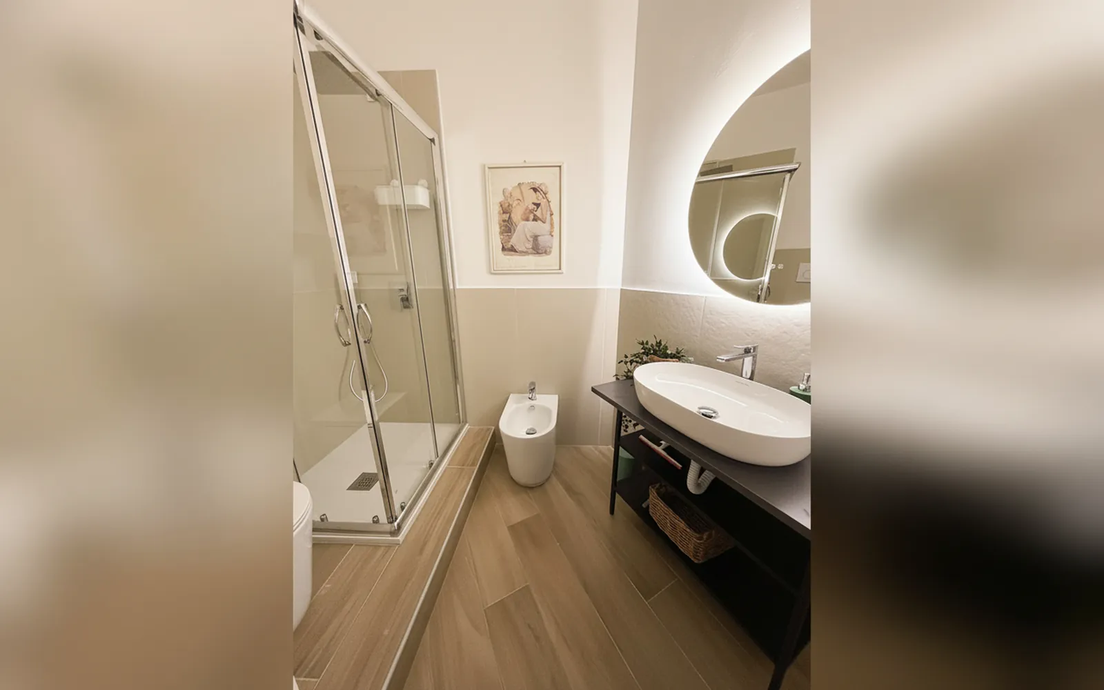Il bagno privato con la doccia in cristallo, il lavabo e il bidet