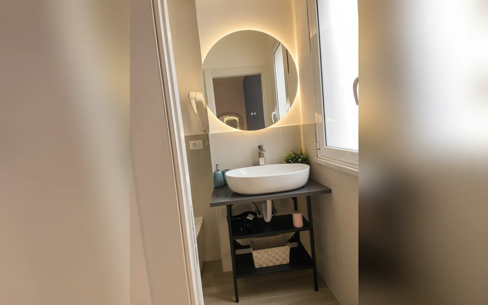 Il bagno privato della suite con lo specchio tondo illuminato